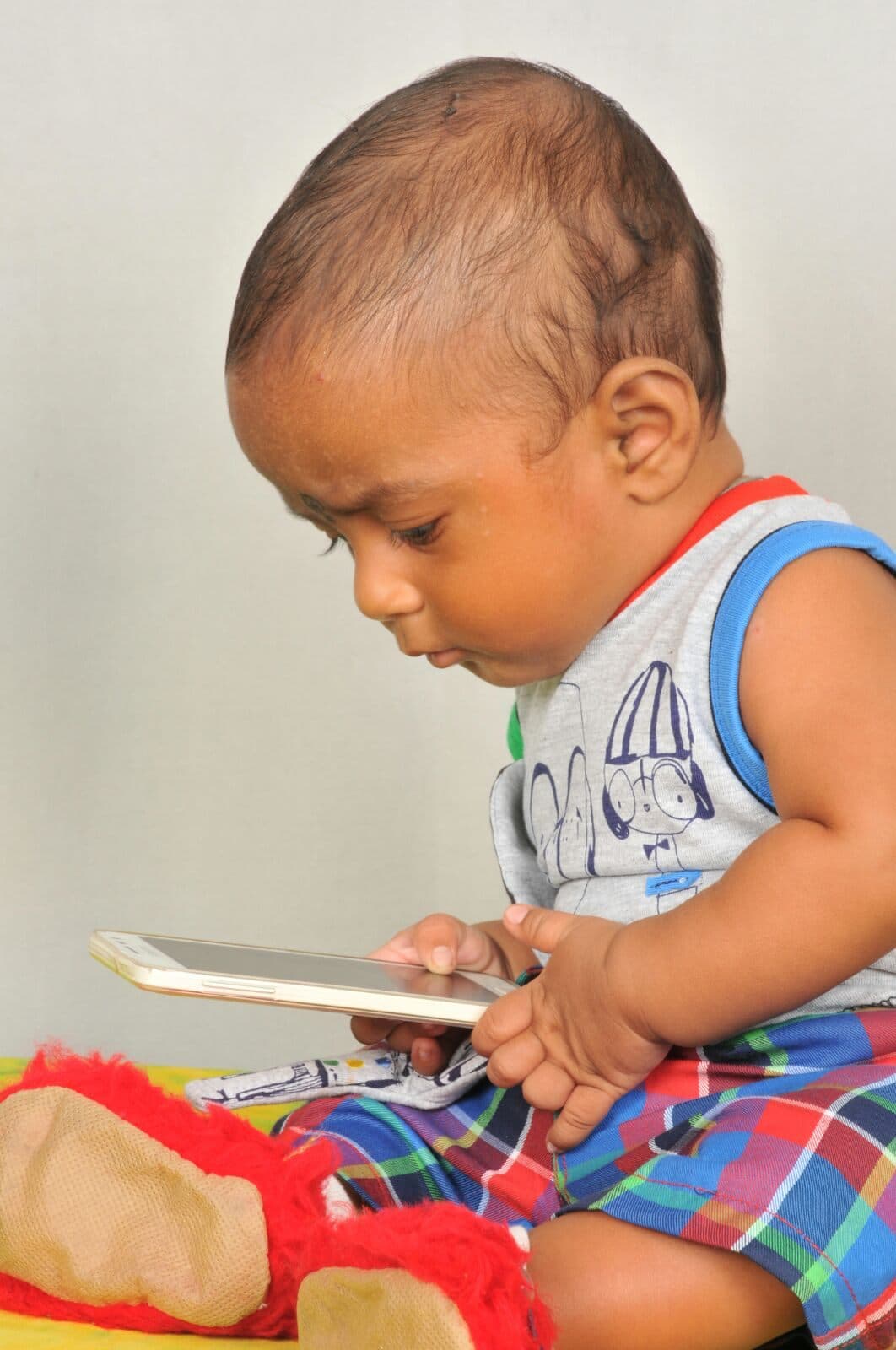 Baby Nihan looking at a phone, close-up