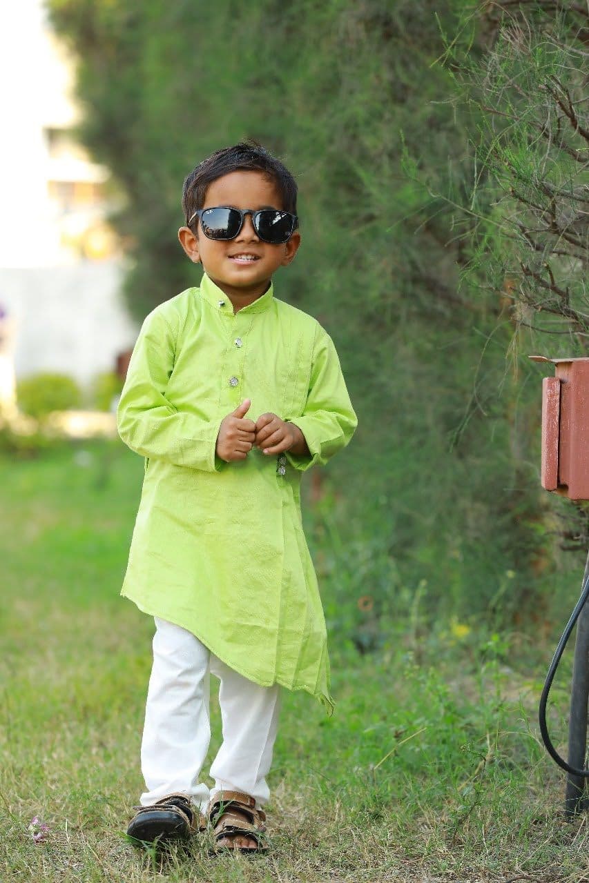 Nihan in a lime-green kurta, white trousers and sunglasses in a garden