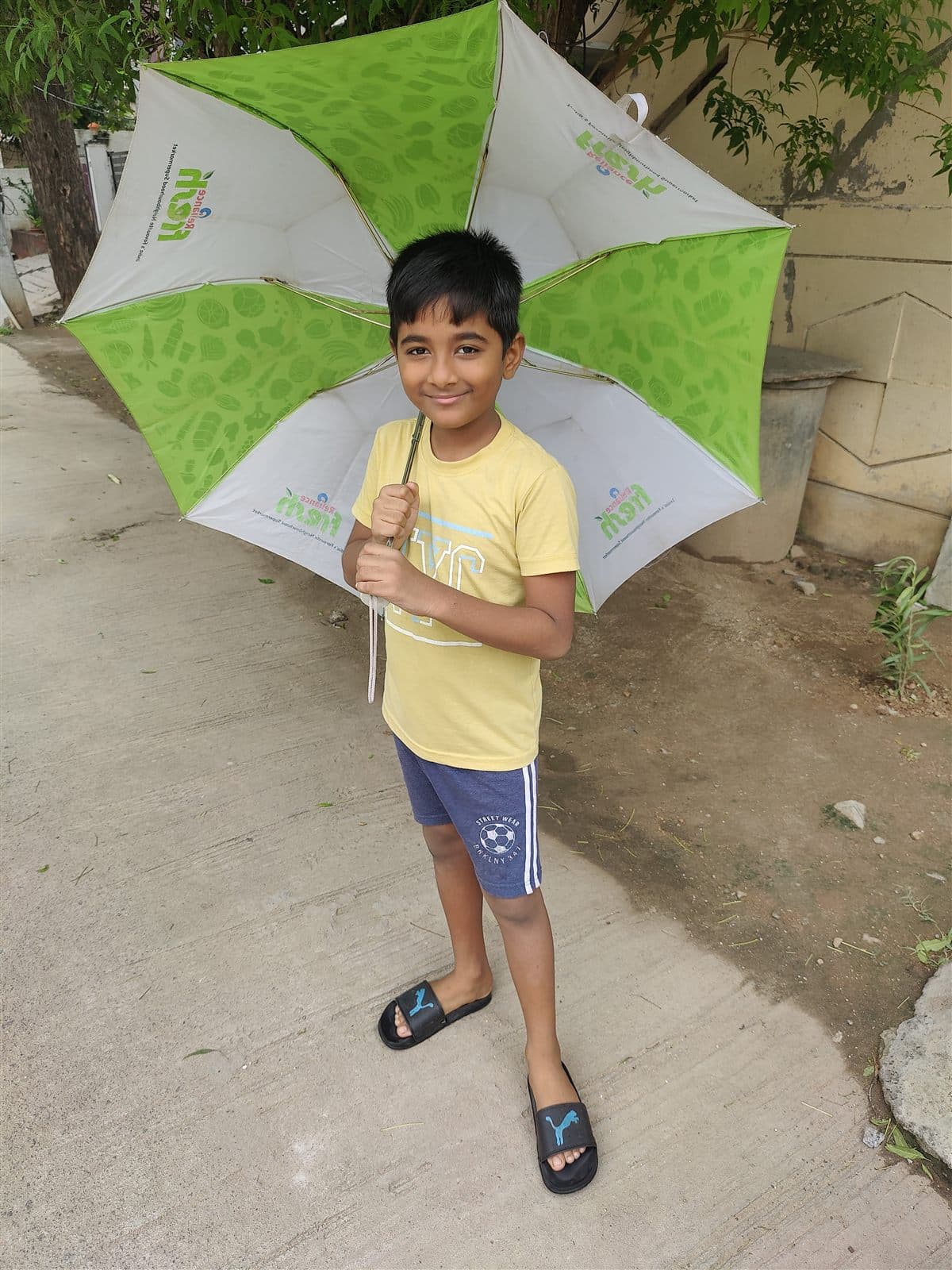 Holding a green and white umbrella in a yellow tee